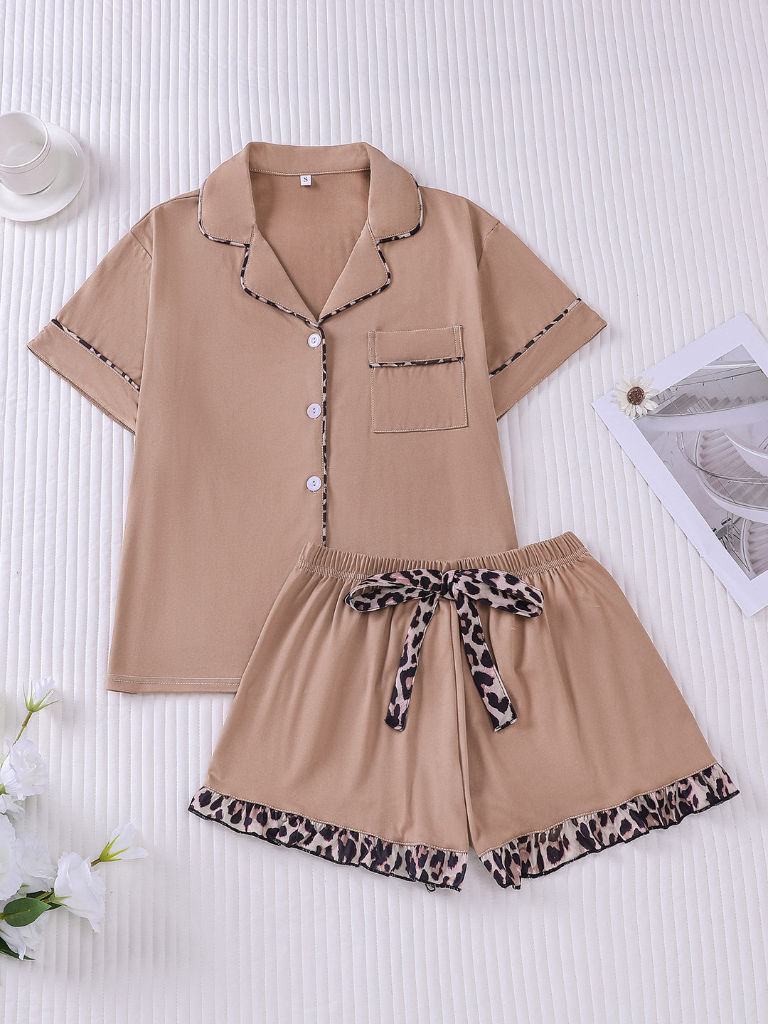 Beige pajama set with leopard print details on a white background