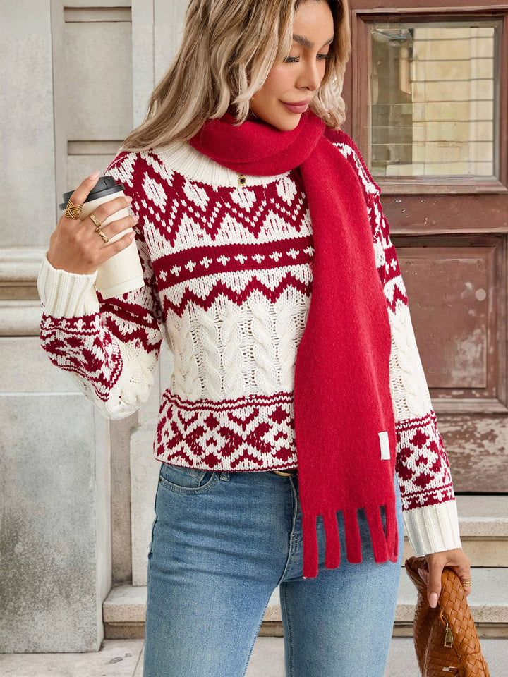 Person wearing a red and white patterned sweater with a red scarf, holding a coffee cup.
