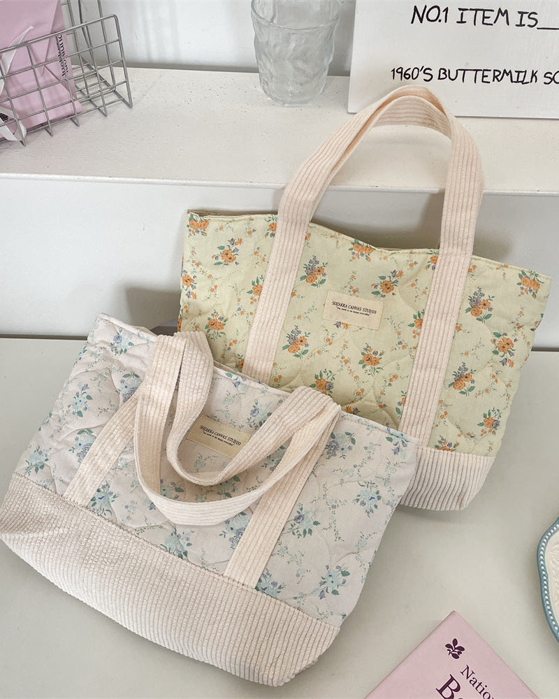 Two floral-patterned tote bags on a light surface with a blurred background.