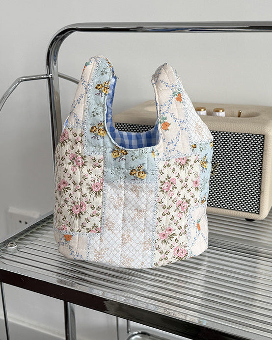 Floral-patterned reusable bag on a metal shelf with a bottle and box in the background.