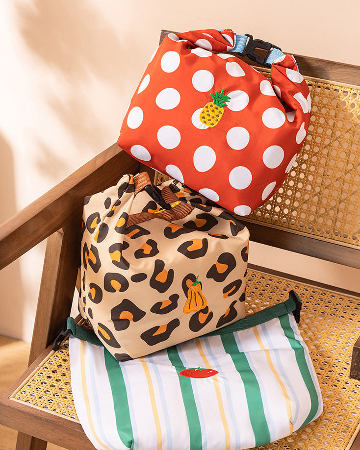 Three bags with different patterns on a chair.