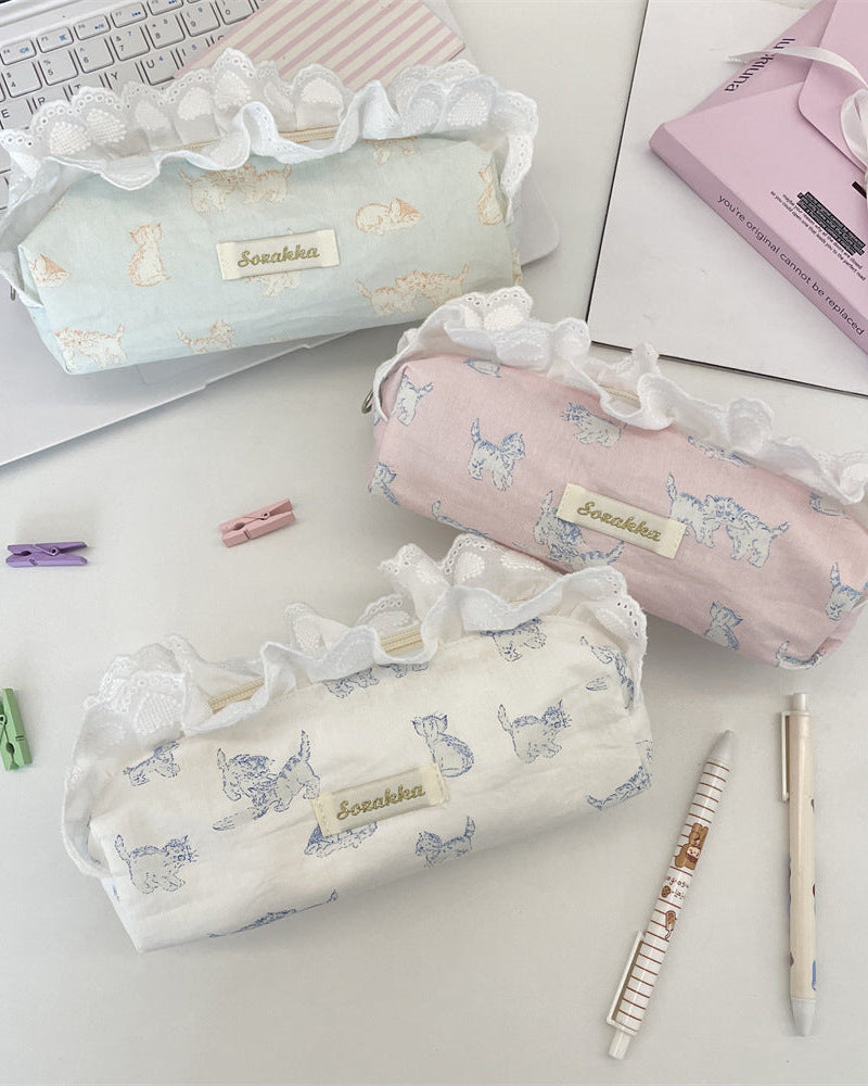 Three decorative pencil cases on a desk with stationery items.