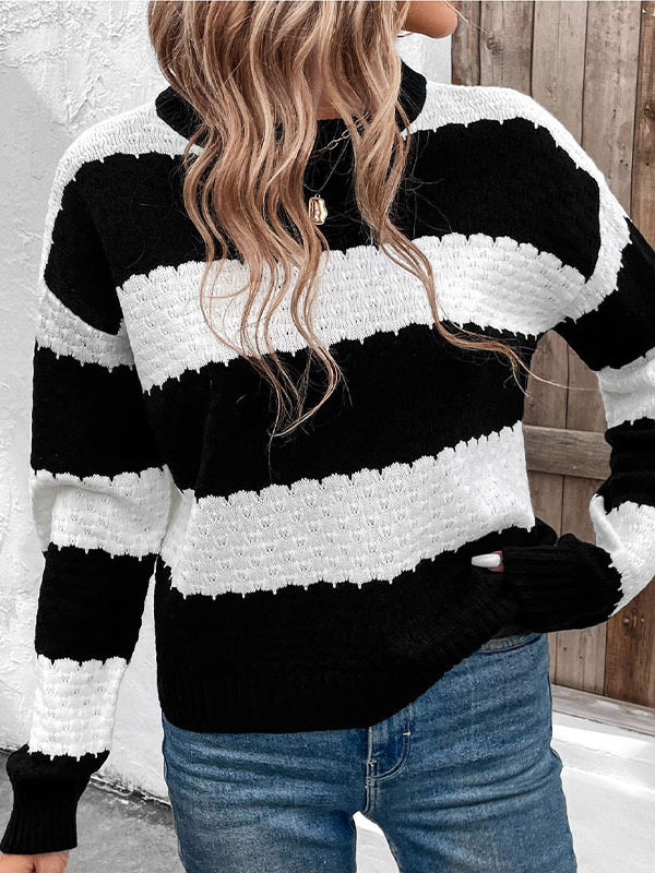 Person wearing a black and white striped sweater with a blurred background