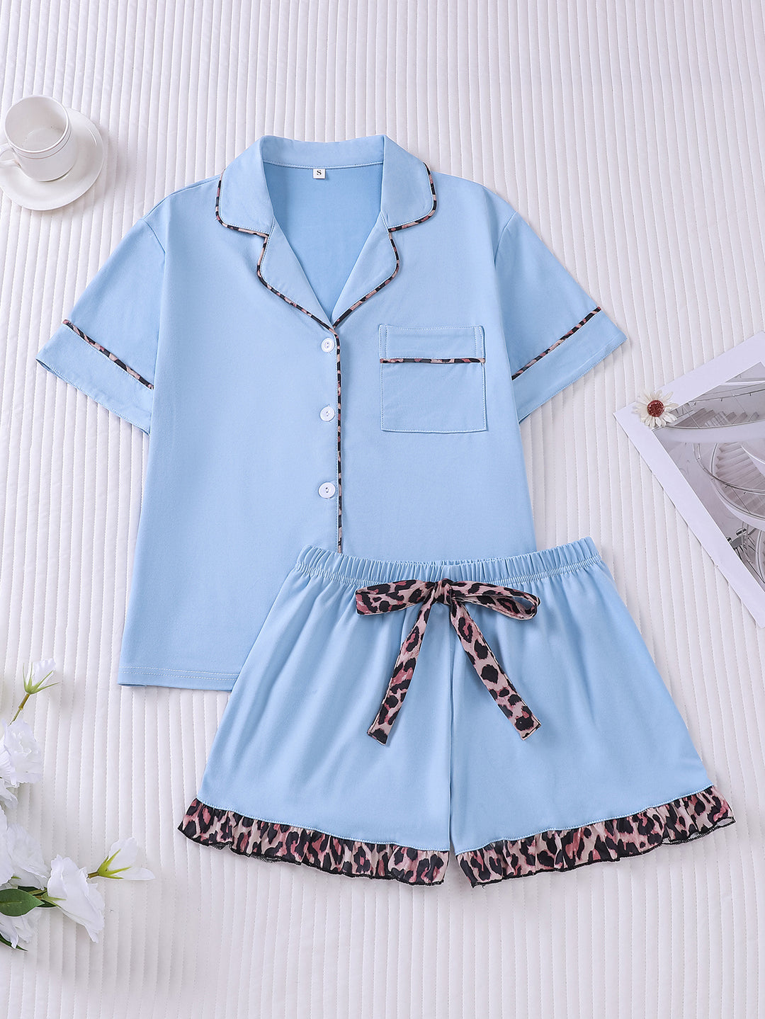 Light blue pajama set with leopard print details on a white background