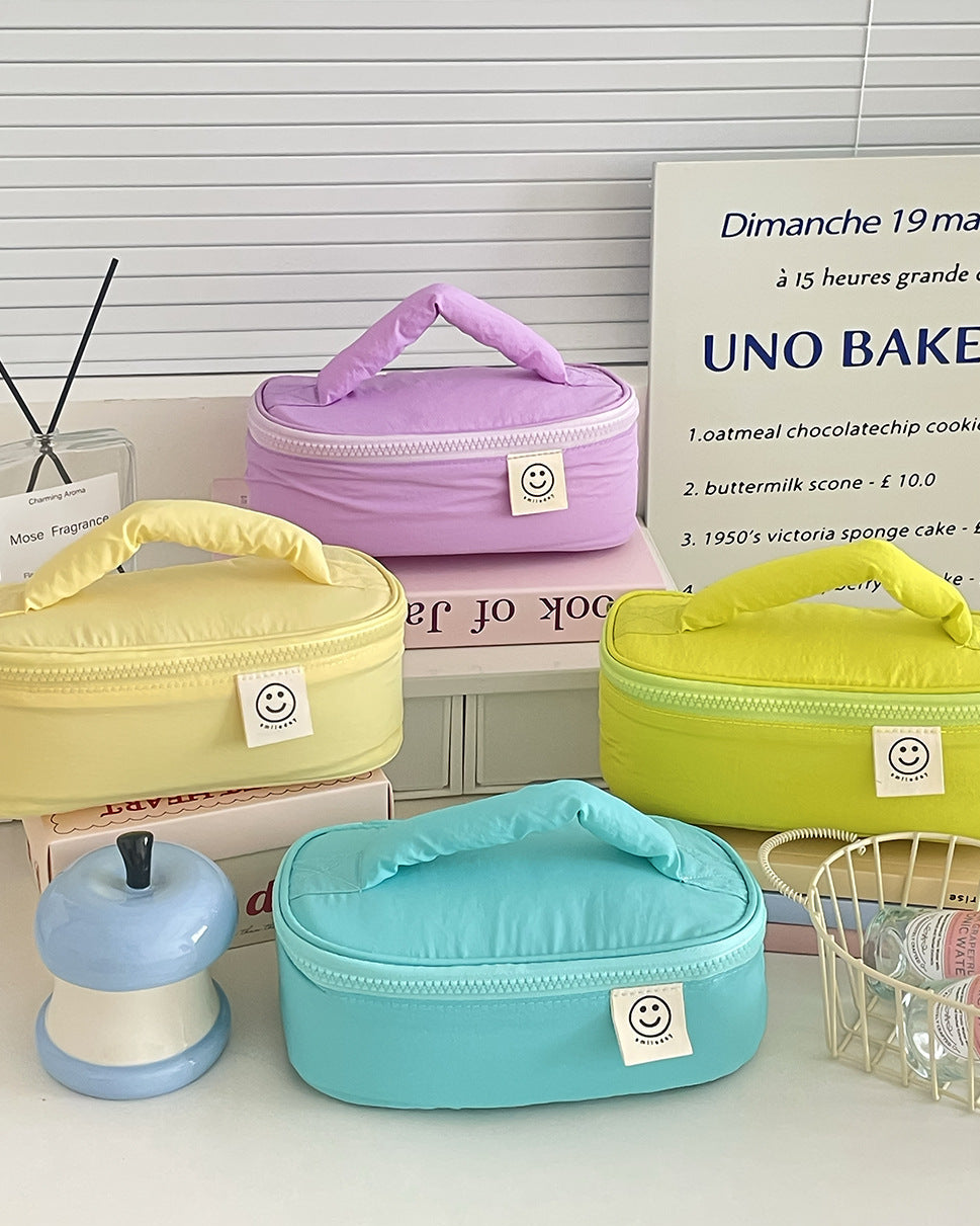 Set of colorful oval storage bags with smiley faces on a surface with a blurred background.