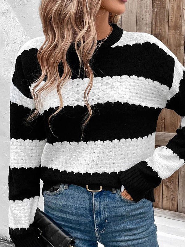 Person wearing a black and white striped sweater with blue jeans.