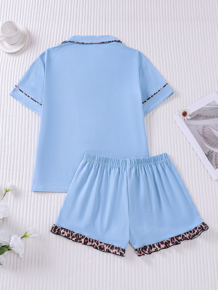 Light blue pajama set with leopard print trim on a white background