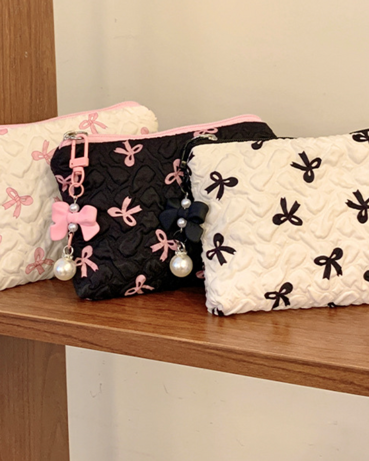 Three pouches with bow designs on a wooden surface
