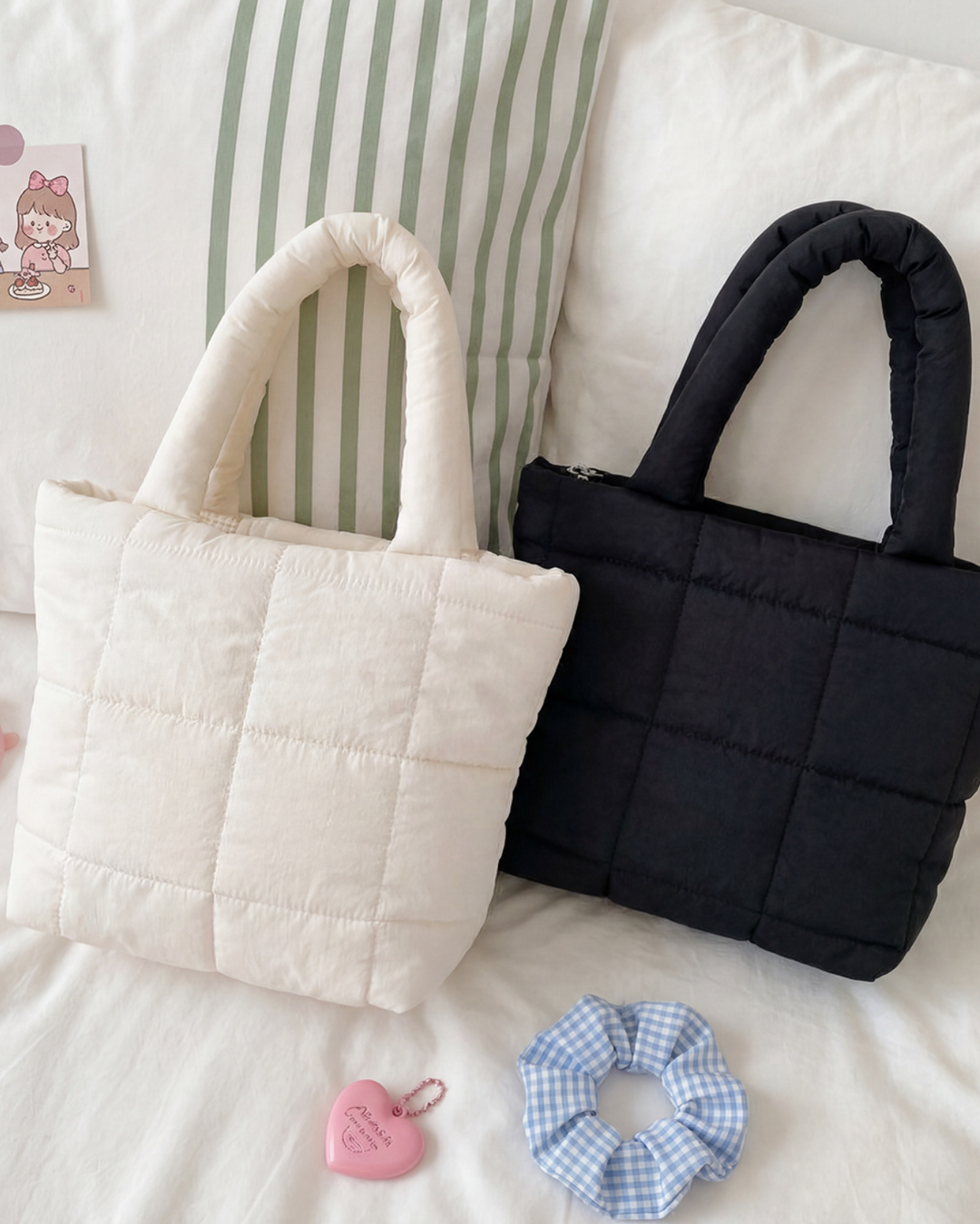 Two quilted handbags, one white and one black, on a bed with sunglasses and a scrunchie.