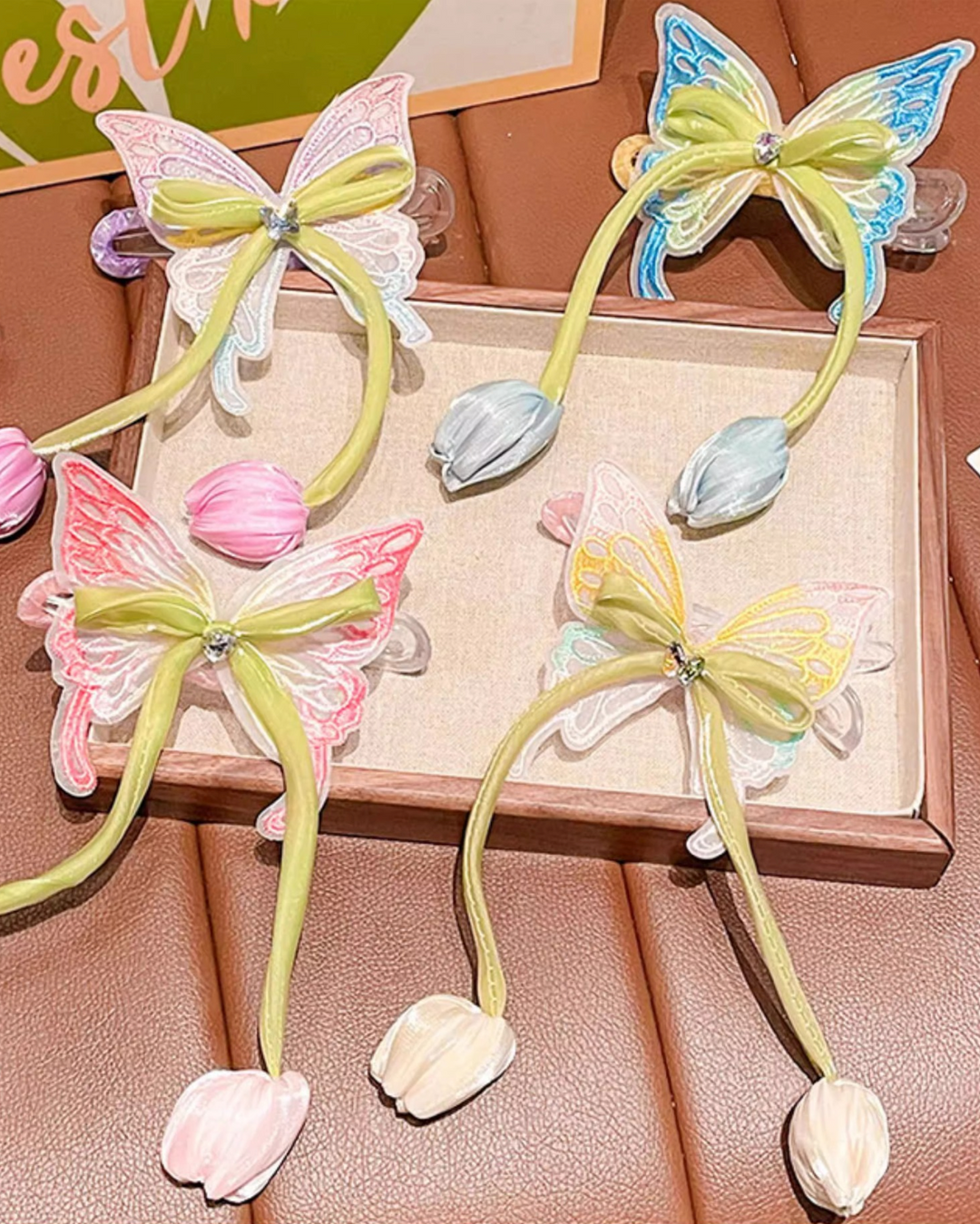 Butterfly-shaped hair accessories with floral details on a wooden surface.