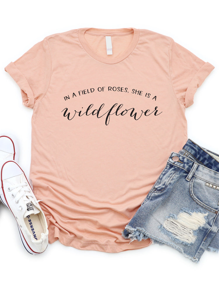In a field of Roses be a wildflower Graphic Tee
